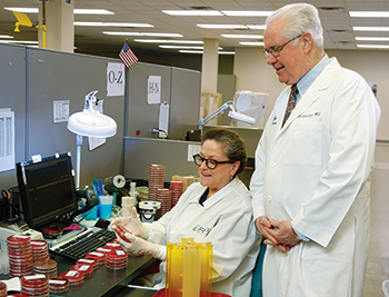 In microbiology, the data warehouse has fostered process improvement, leading to shorter TATs. “Historically, we would read cultures every morning, and we didn’t necessarily adjust for time of incubation.” Urine cultures are read now in precisely 18 hours. “We have determined using the data warehouse the optimal time,” says Dr. Dolan, here with medical technologist Carol Powers.