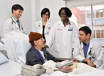 The team, whose meetings with patients are ongoing, consists of, from right, hospitalist Balal Ahmed, MBBS, Dr. Julietta Fiscella, and residents and students. Dr. Fiscella provides the team with mini reviews of staining, cellular structure, and other aspects of surgical pathology.