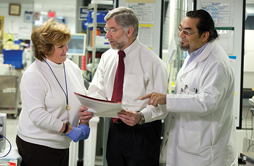 John Waugh with Ruth Doubleday, lab systems analyst. and Ralph Benitez, supervisor of lab support services. Laboratories continue to get disproportionately hit by reimbursement cuts, Waugh says, because they are more of a “back of the house” function.