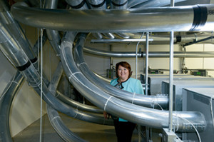 Tammy Germini in the pneumatic tube room that houses the Pevco Smart Path system (lower right) and next to the upgraded pneumatic tube system (above). They expect the travel time for specimen delivery to be cut in half.