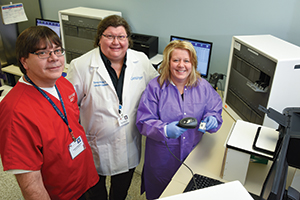 Dr. Wolk (center) with Francis Tomashefski, BS, MT(ASCP), and Lisa Scicchitano, BS, MT(ASCP). Laboratories in the U.S. are often falsely labeled as cost centers, Dr. Wolk says, but she and colleagues see their lab as a “cost recovery center,” and they aim to prove it for every laboratory intervention they make.