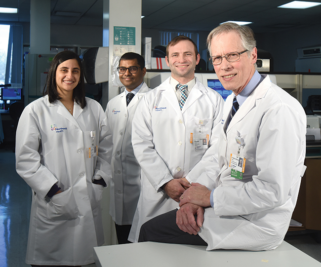 Dr. James Crawford (right) with (from left) Reeti Khare, PhD, assistant director of infectious disease diagnostics; Tarush Kothari, MD, MPH, physician informaticist; and Yehuda Jacobs, software architect. The question Dr. Crawford asks his laboratory colleagues is, “Can you demonstrate that patients are better for having received care from your lab as opposed to from other labs?”